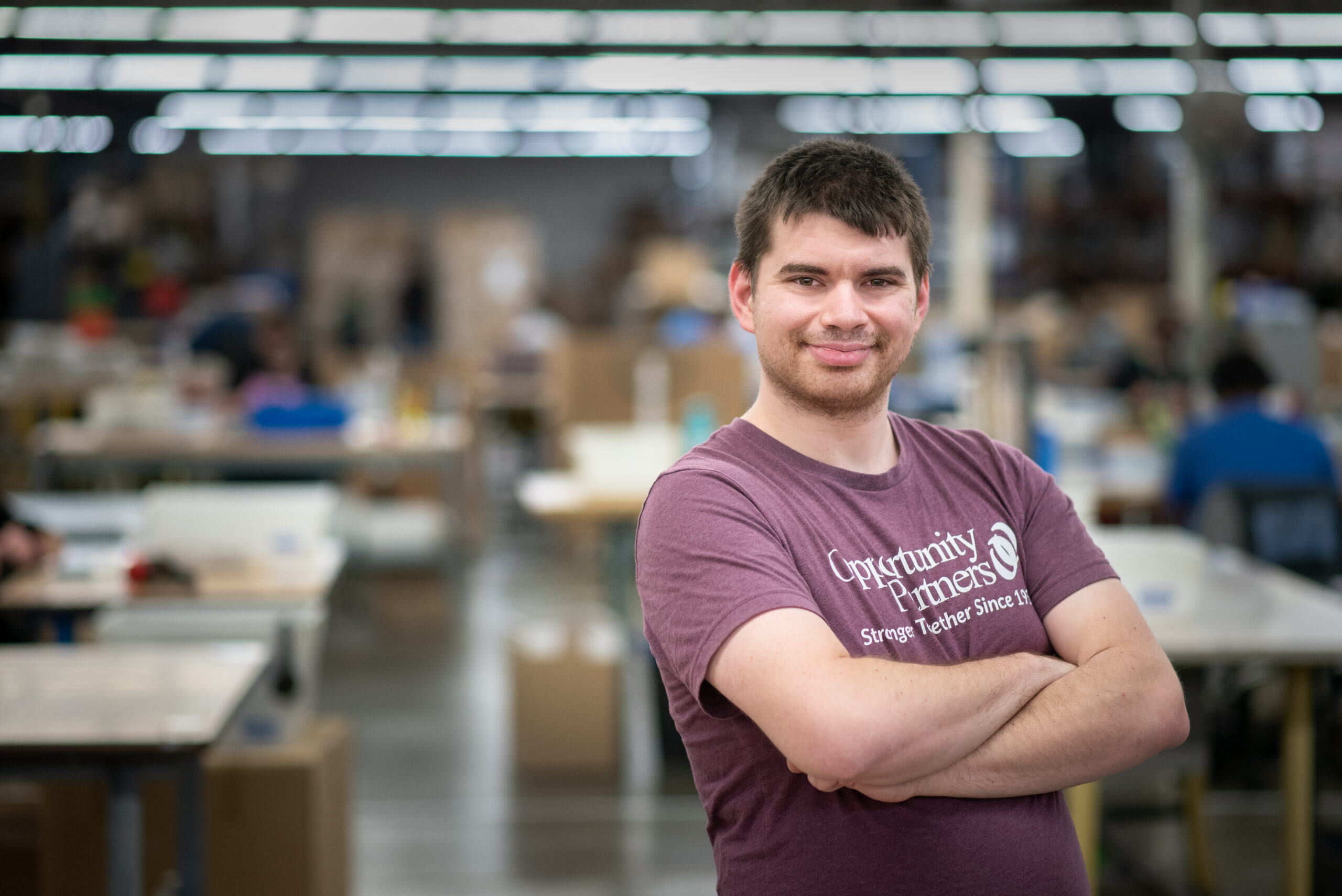 Man with arms crossed on production floor