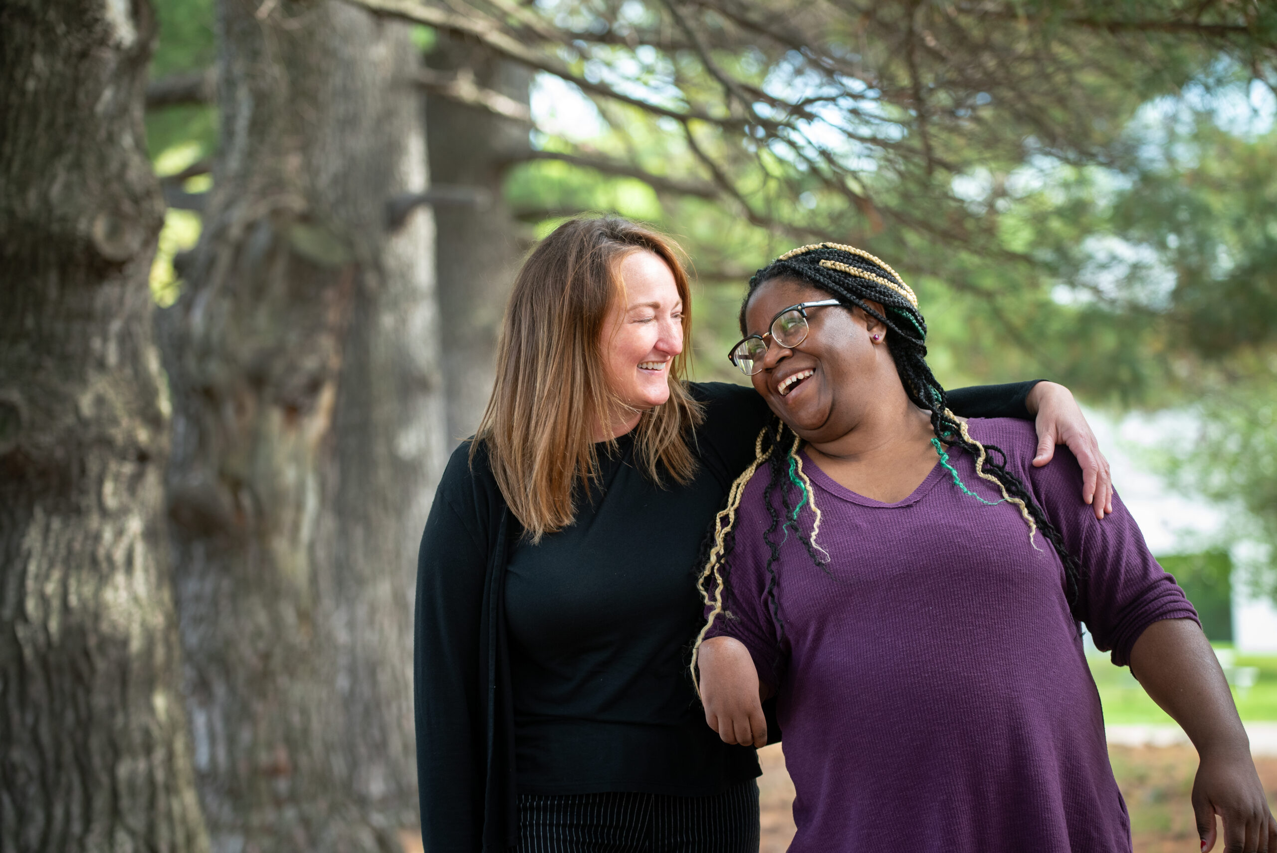 Staff and person served smiling together outside