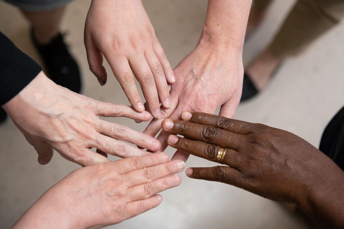 Hands of people together in a circle
