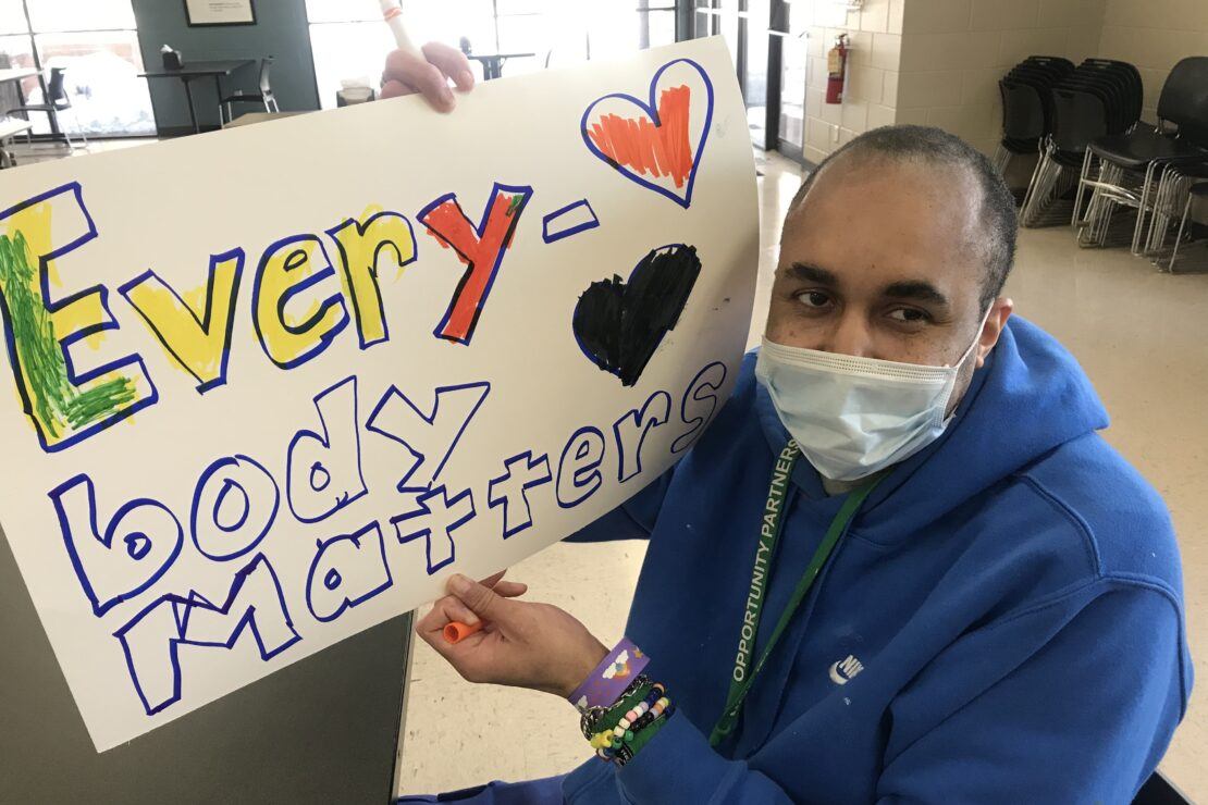 Man holding sign that says Everybody Matters