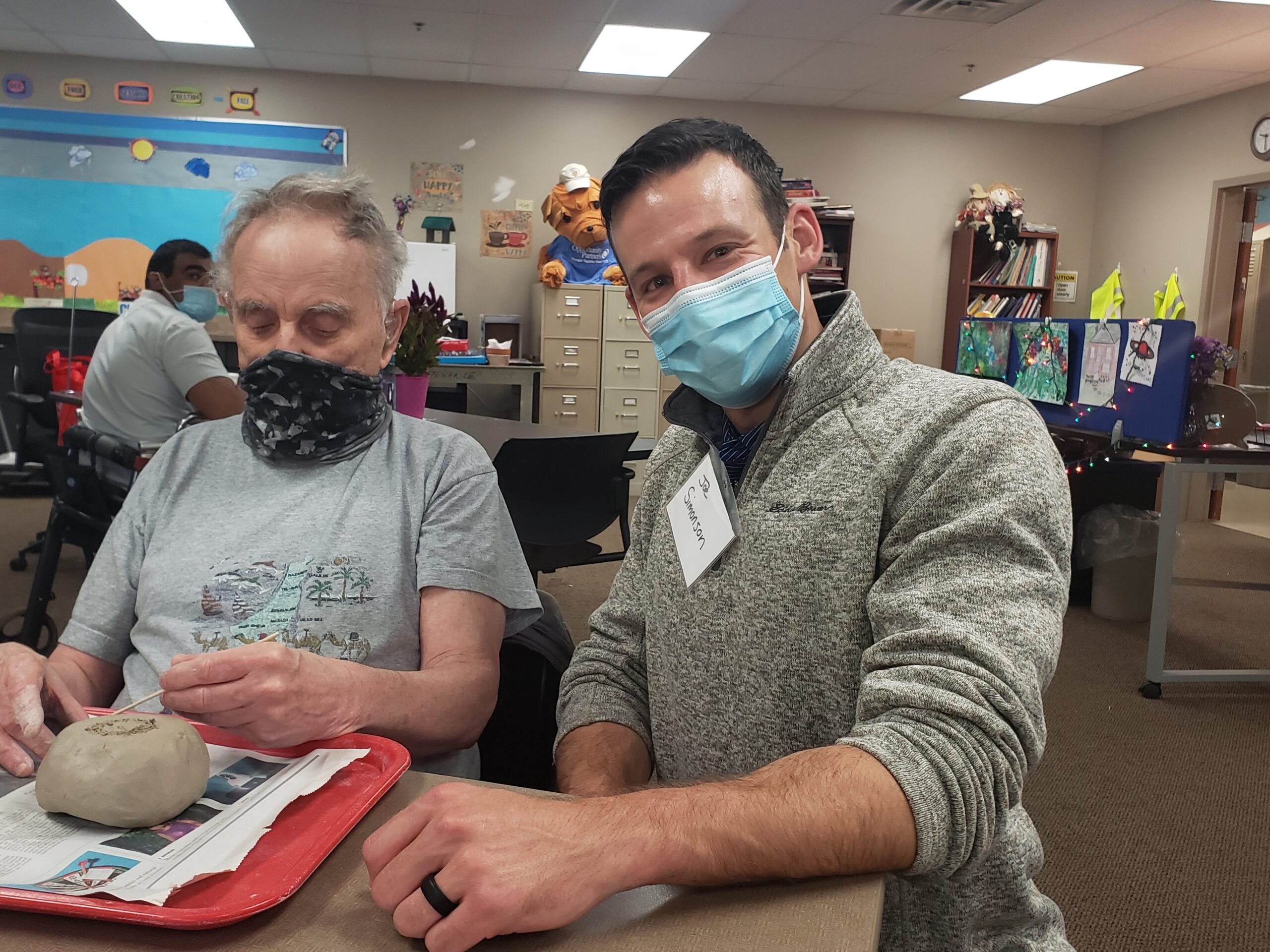 Person served and volunteer in classroom