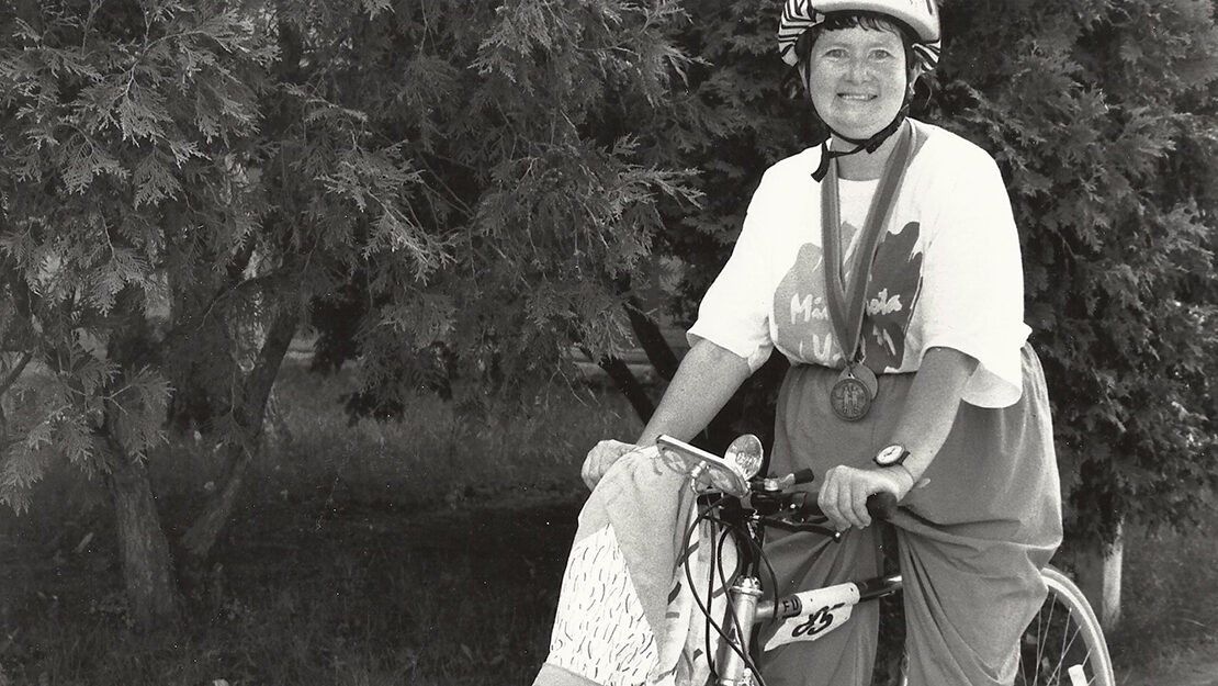 Black and white photo of woman on bike