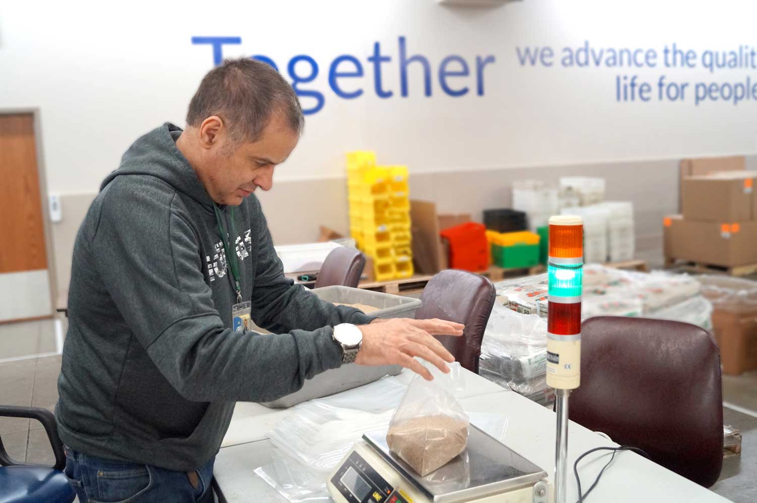 Rick works on weighing bags of sand to fill test boxes.