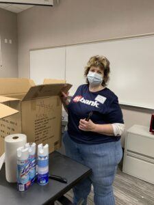 Woman in a US Bank shirt and mask smiling