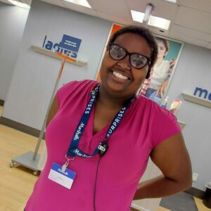 Woman in a pink shirt and glasses smiling