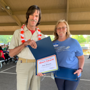 A man and a woman smiling holding a certificate