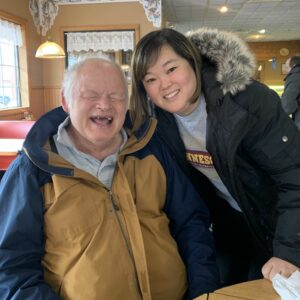 A man and a woman posing in a restaurant smiling