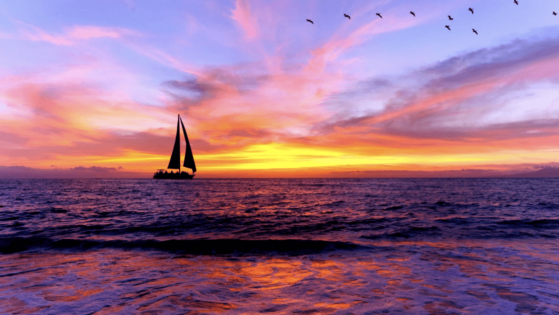 sail boat on water at sunset