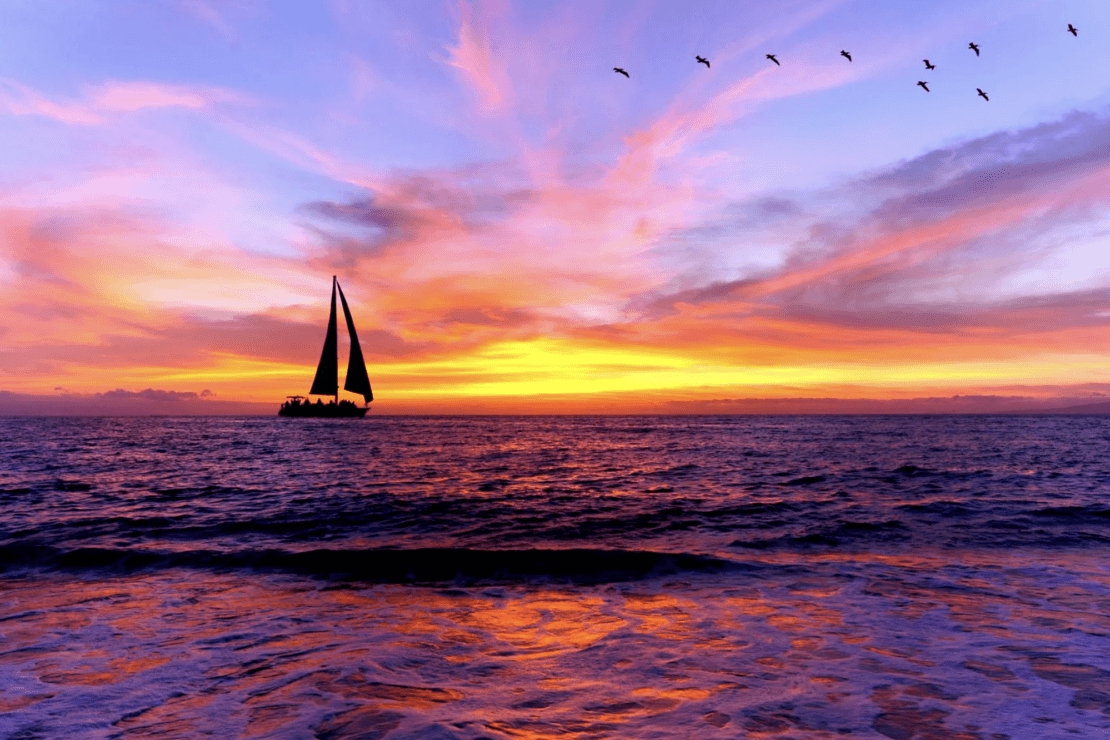 sail boat on water at sunset